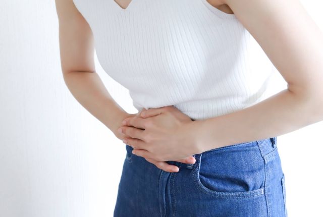 お腹をおさえる女性