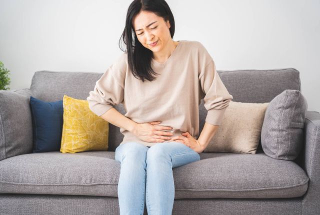 下腹部をおさえる女性